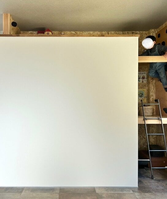 壁のボルダリングを登る子ども