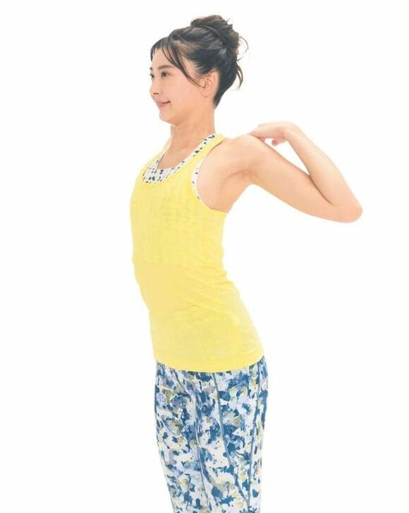 黄色の服を着た女性ひじを回す