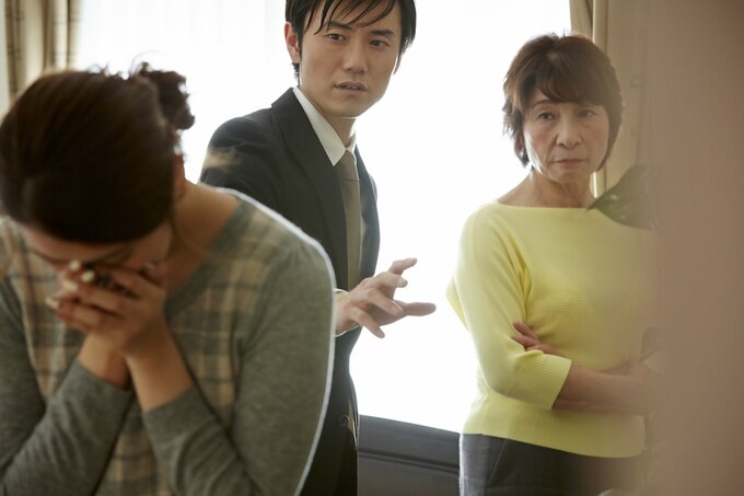 泣く女性と見つめる家族