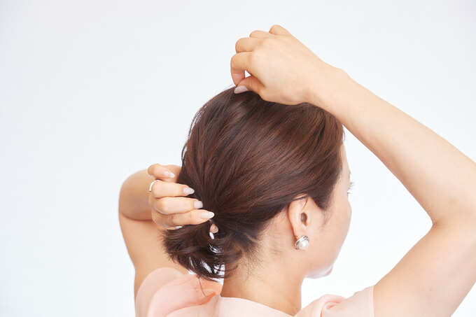トップの髪を引き出す女性