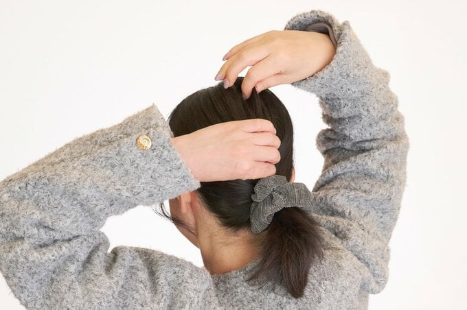 後頭部の毛を引き出す女性