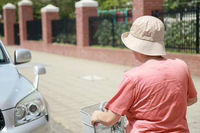 車の前に自転車に乗る女性
