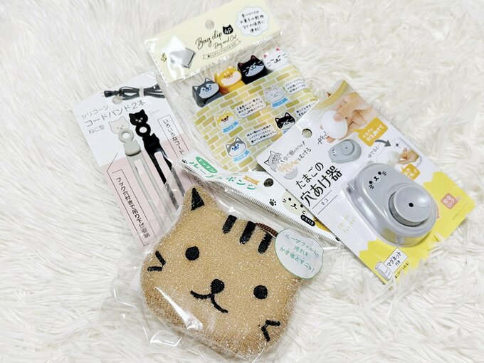 上から時計回りに:「袋とじクリップ4P」「ゆでたまご穴あけ器 ネコ」「ループスポンジねこ」「シリコーンコードバンドねこ型」