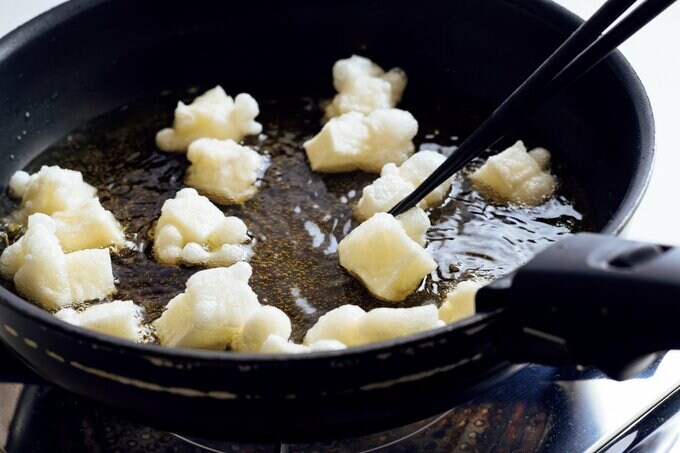 細かく切り分けたおもちを油で揚げる