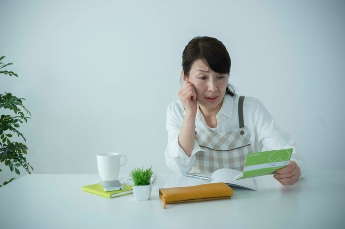 通帳を見るパート主婦
