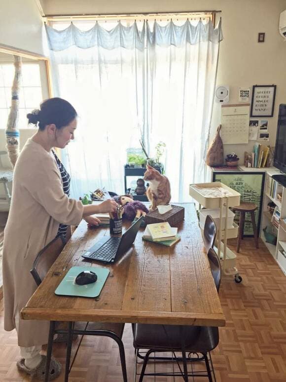 ダイニングテーブルの上を整理する女性の様子