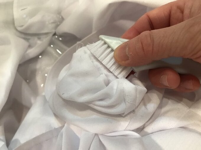 ブラシで糸くずなどをかき出す