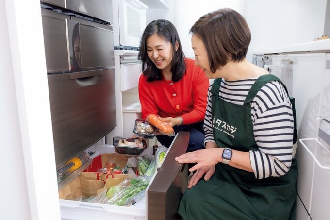 冷蔵庫のなかを見ながら話す女性とハウスキーパー