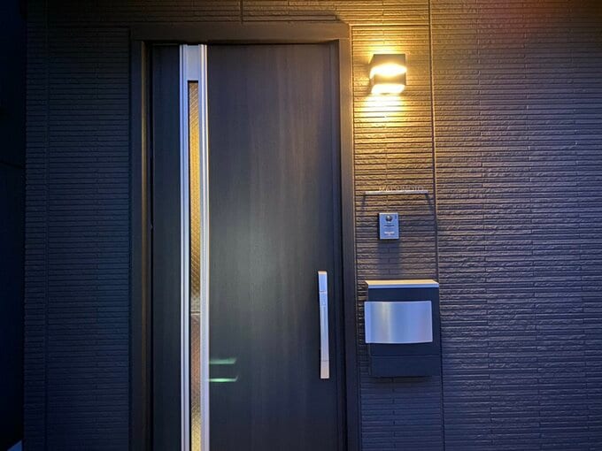 日が暮れて玄関ポーチのライトが点灯している様子