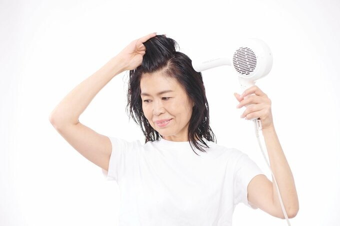 ドライヤーで乾かす女性