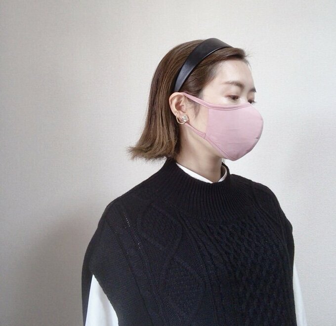 ピンクマスクをつけた黒服の女性