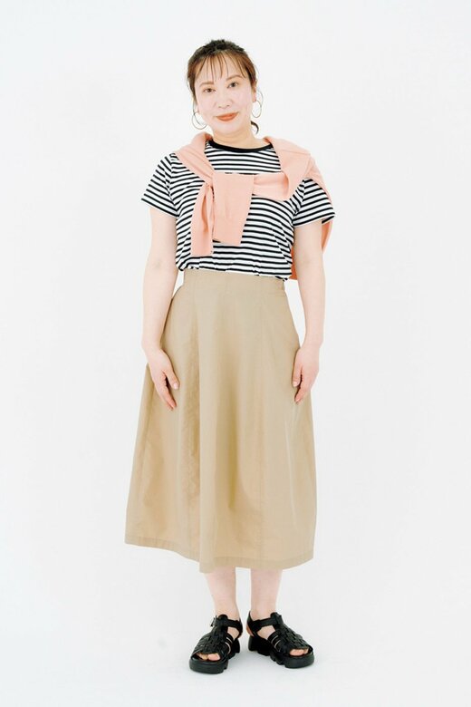 ベージュのひざ下丈スカートを履いた女性