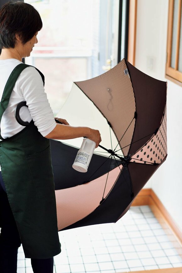 傘にアルコールスプレーをスプレーする様子