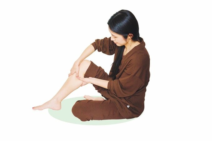 足の内側のツボを押す女性