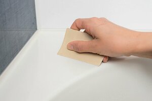 湿布した浴槽の縁をカードでこすり洗い