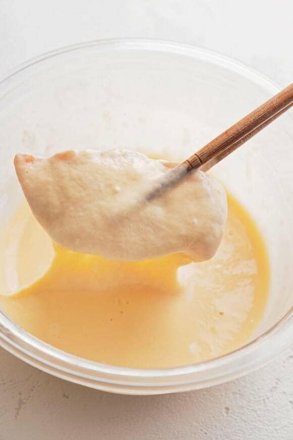 肉のをバッター液にくぐらせる様子