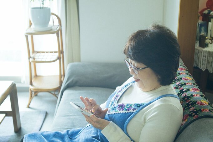 スマホゲームをする足立さん