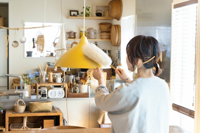 照明をホコリとりで拭いている図