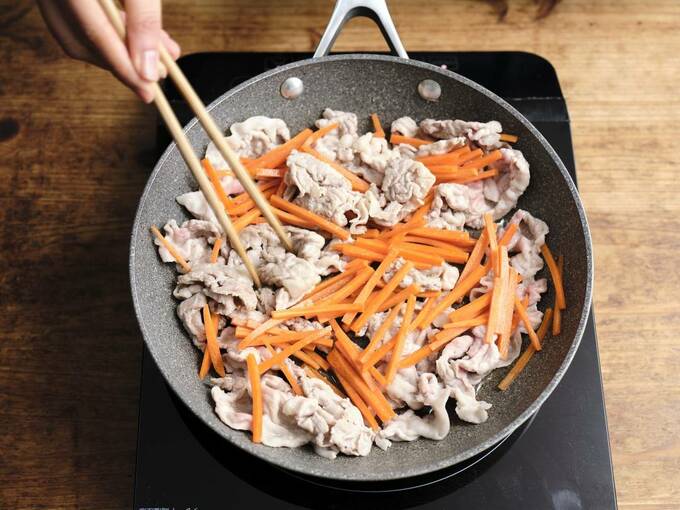 油をひいて豚肉とニンジンを炒める