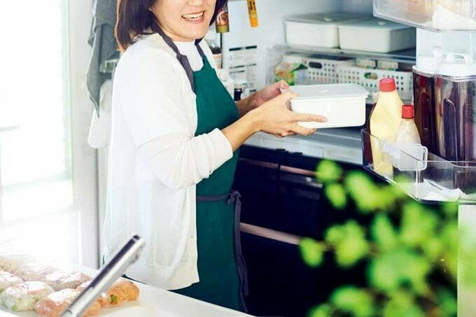 冷蔵庫に保存容器を入れる女性