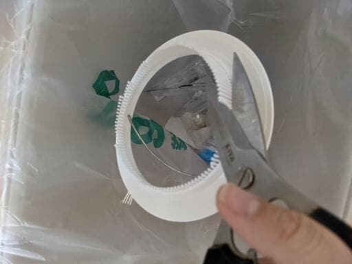 100均の白いプラスチック製の排水カゴを調理ハサミでカット