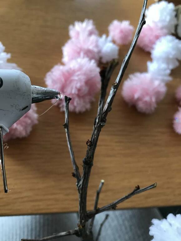 ポンポンを枝にグルーガンでとめる