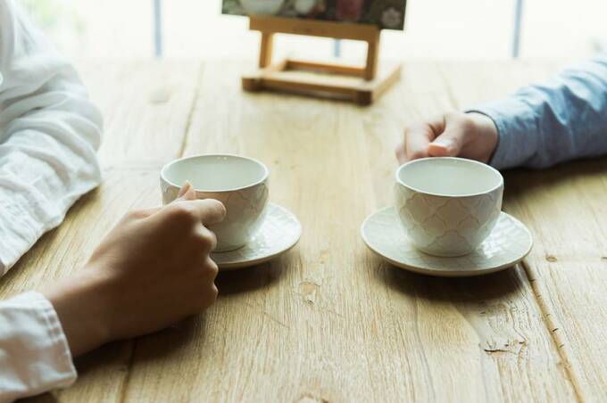 向かい合ってコップを持つ様子