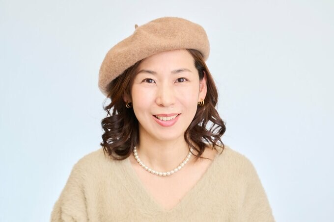 耳かけをしてベレー帽をかぶる女性
