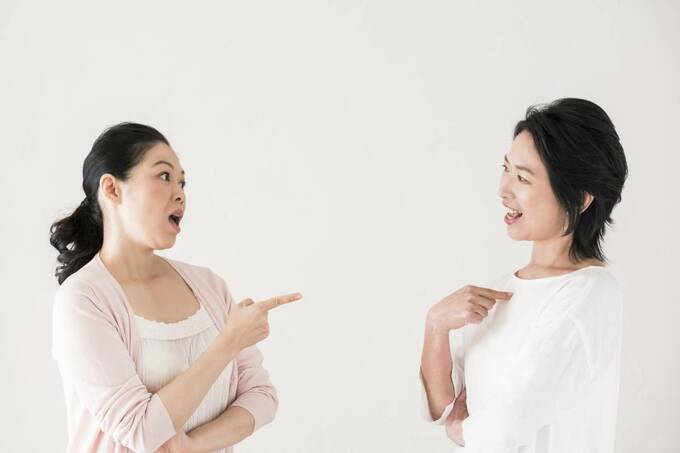 指差しをして話す女性2人