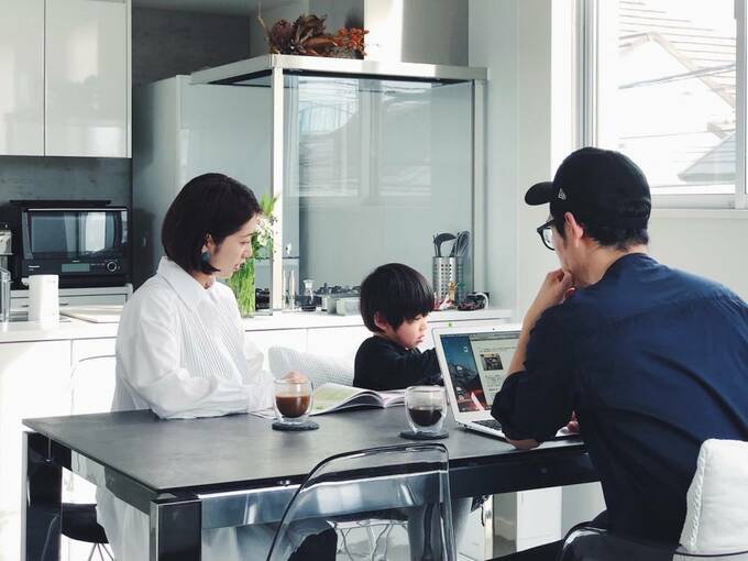 パソコンを操作する男性と本を読む女性と子ども