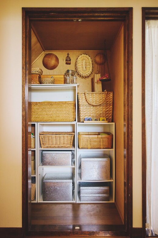 カゴとトタンボックスが収納された、扉の無い階段下収納