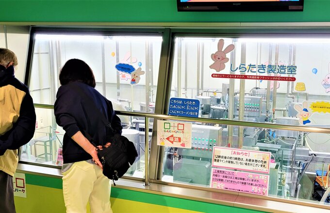 窓越しに製造ラインが見える工場見学通路