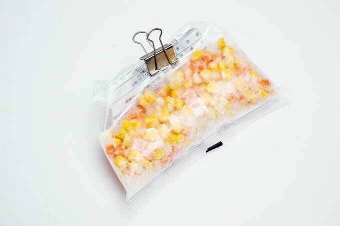ダブルクリップで封をした冷凍のつぶつぶコーンの袋