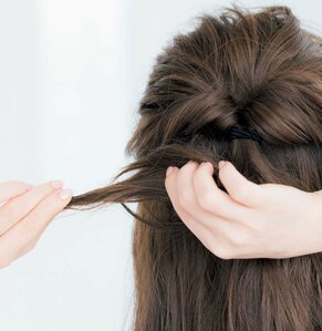 右手で髪を押さえて左手で少量ひっぱる