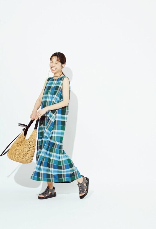チェックワンピースとレースアップサンダルを身に着けた女性