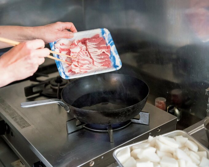 フライパンに肉を入れる