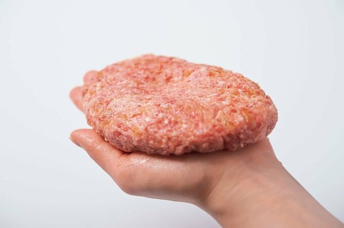 手に楕円形にしたハンバーグ