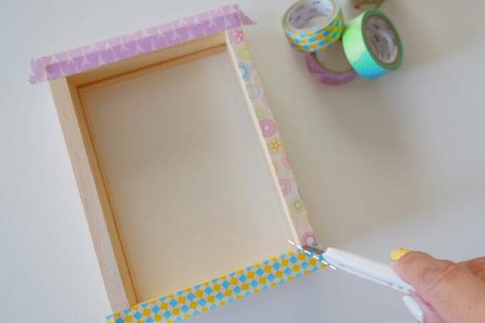 写真のフチとなる部分に好きなマスキングテープをはる様子