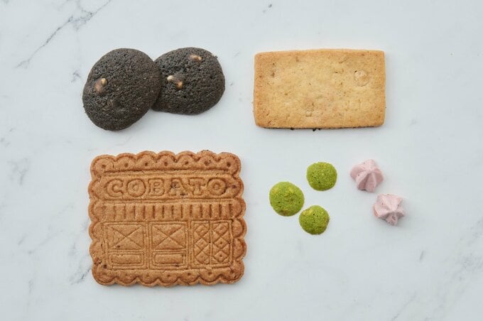 メープル胡桃のクッキー（右上）、カシスのメレンゲ（右下）、ブラックココアとホワイトチョコのサブレー（左上）、ピスタチオラングドシャ（左中央）、山椒とチョコレートのスペキュロス（左下）