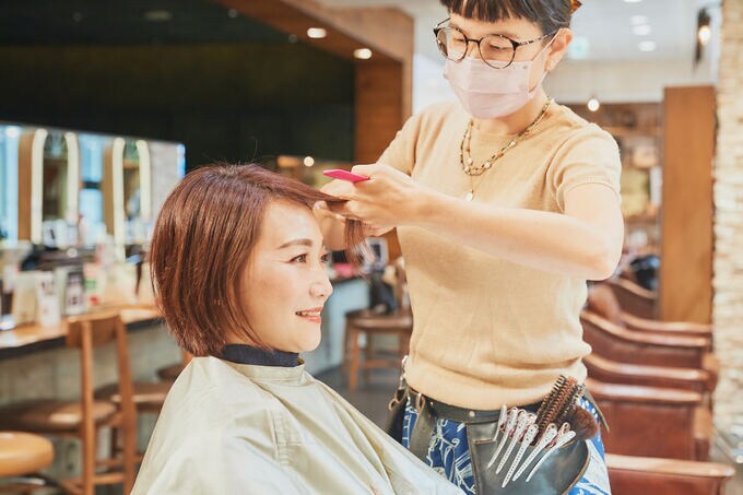 髪を切る女性と美容師
