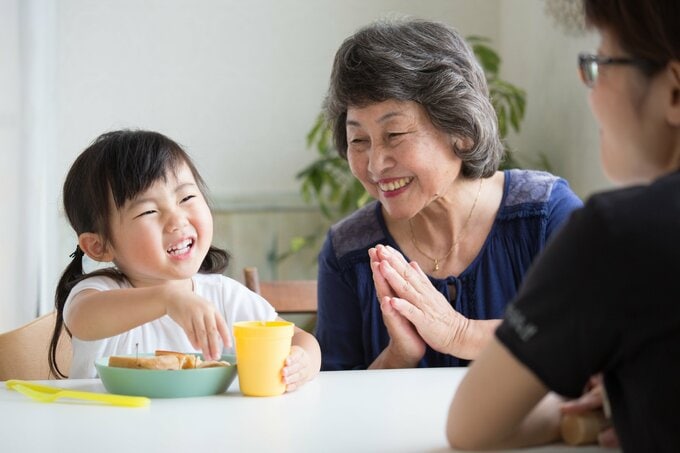 孫と外食するシニア女性