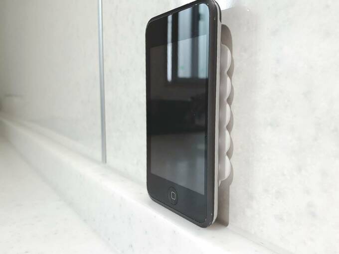 壁の吸着シートにスマホ
