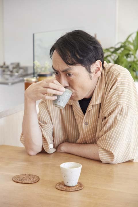 太陽熱調理器「エコ作」でつくったお湯と、ガスで沸かしたお湯と飲み比べる田中さん