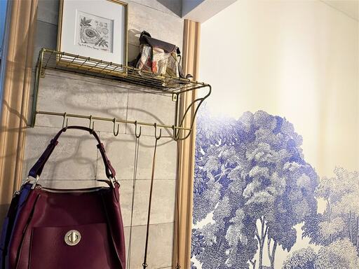 取り付けたワイヤーシェルフにバッグを掛けたり絵を飾ったりしている