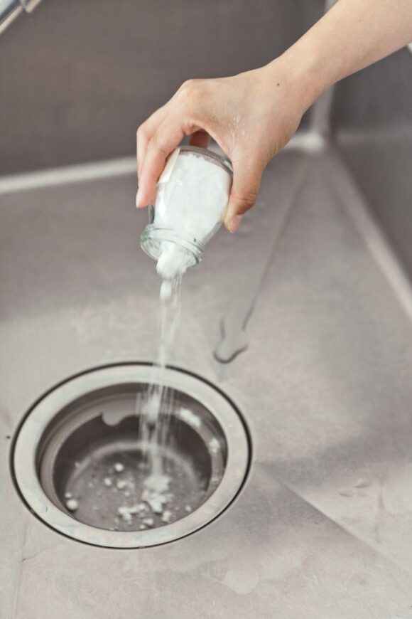 芳香剤を排水溝にふりかける様子