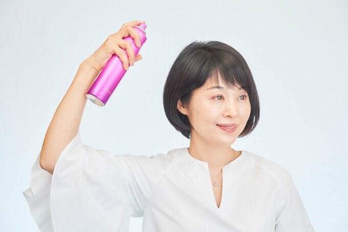 スプレーをかける女性