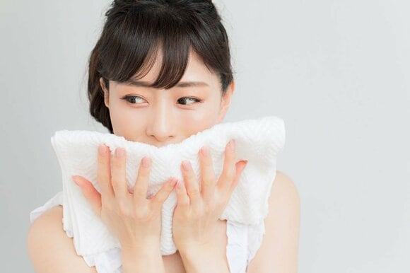 タオルを口元に女性