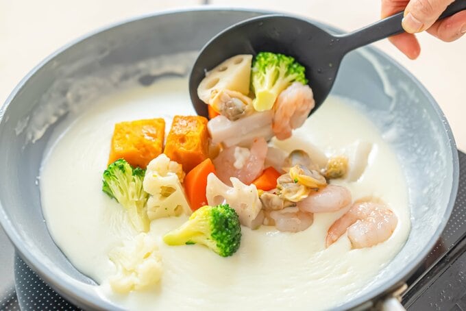 フライパンに食材をくわえる