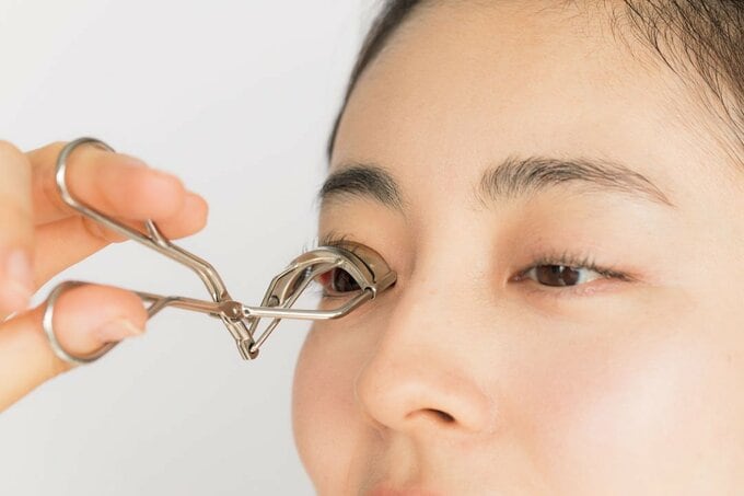 ビューラーでまつげを上げている様子