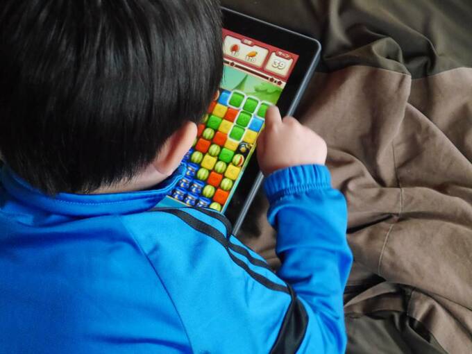 タブレットでゲームをする子ども